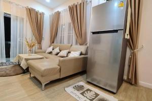 a living room with a couch and a refrigerator at KANA Homehug in Ban Nong Hin
