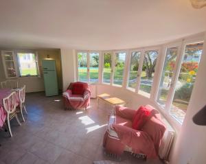 a living room with chairs and a table and windows at Private Swimmingpool in Cottage in Poros