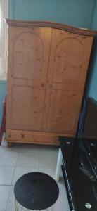 un armario de madera en una cocina con taburete en Studio au calme en Péronnas