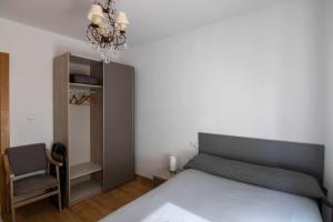 1 dormitorio con 1 cama, 1 silla y 1 lámpara de araña en Apartamento paris, en León