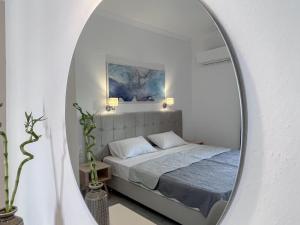 a bedroom with a bed and a mirror at ATHANASIA APARTMENTS in Skiathos