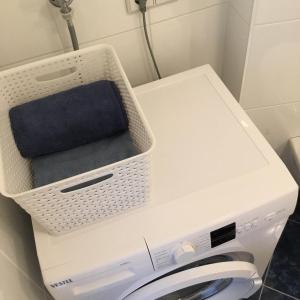 a white washing machine with a basket on top of it at Earl Grey Apartment Wien in Vienna
