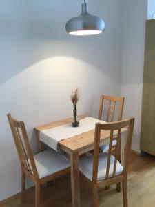 une table avec deux chaises et un vase avec une plante dans l'établissement Earl Grey Apartment Wien, à Vienne