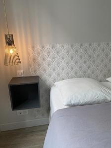 1 dormitorio con 1 cama, TV y pared en Hysope : Studio aux couleurs toutes douces !, en Bagnères-de-Bigorre