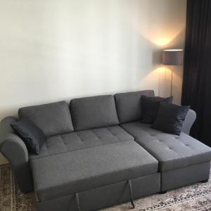 un sofá gris en una sala de estar con lámpara en Earl Grey Apartment Wien, en Viena