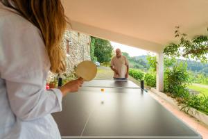 Uma mulher está a jogar pingue-pongue. em Casa do Castelo em Arnóia em Celorico de Basto