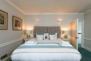 sypialnia z dużym białym łóżkiem z poduszkami w obiekcie Abbey Mews in the heart of Bath w mieście Bath