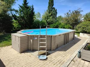 a large swimming pool with a ladder next to it at Le soleil souriant in Banne