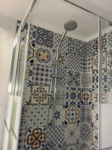 y baño con ducha y azulejos azules y blancos. en Maison Silvia, en Nápoles