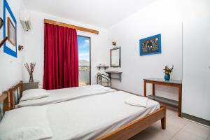 two beds in a room with a window at Ano Kampos Hotel & Suites in Faliraki