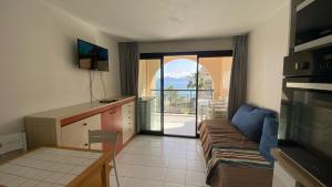 un soggiorno con un divano e una porta scorrevole in vetro di Cannes Front Beach Pools Apartment a Cannes