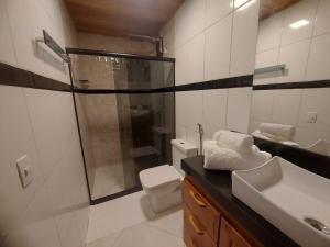 y baño con ducha, aseo y lavamanos. en Casa Duplex em Pedra Azul, en Domingos Martins