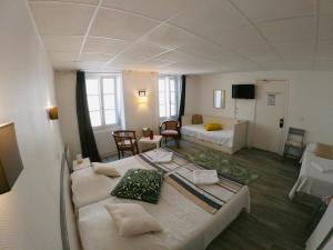 Großes Zimmer mit einem Bett und einem Wohnzimmer. in der Unterkunft Le Petit Hôtel in Biarritz