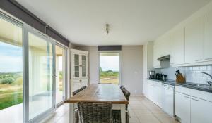 a kitchen with a wooden table and a large window at Vue sur mer, dunes et golf in Wimereux