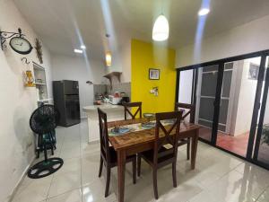 a kitchen and dining room with a wooden table and chairs at House at Centro Histórico with pool in Mérida