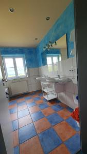 ein Badezimmer mit blauen und orangefarbenen Fliesenböden in der Unterkunft Alpenblick in Leutkirch im Allgäu