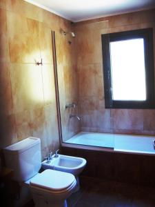 une salle de bain avec toilettes et baignoire dans l'établissement Miralagos Apart & Cabañas, à Villa Pehuenia 30 autres photos