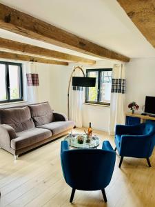 ein Wohnzimmer mit einer Couch und einem Tisch und Stühlen in der Unterkunft Corps de ferme alsacien in Grassendorf