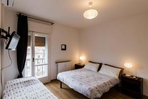 um quarto com uma cama, uma televisão e uma janela em Appartamento Slataper - ampio e con vista em Trieste