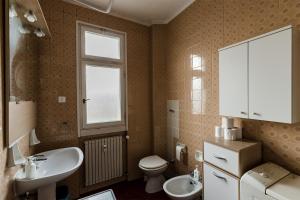 bagno con lavandino, servizi igienici e finestra di Appartamento Slataper - ampio e con vista a Trieste