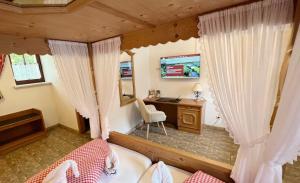 Schlafzimmer mit einem Bett, einem Schreibtisch und Vorhängen in der Unterkunft Hotel Sonnekalb in Naumburg