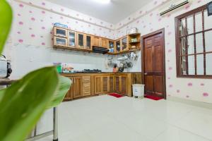 a kitchen with wooden cabinets and a window at Bách Khoa Motel in Vung Tau