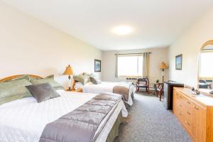 a hotel room with two beds and a desk at Waterton Country Villas in Waterton Park