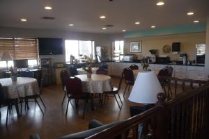 a restaurant with tables and chairs and a kitchen at Sierra Inn in Sierra Vista