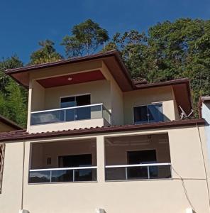 une maison avec un balcon au-dessus dans l'établissement Casa Duplex em Pedra Azul, à Domingos Martins