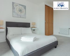 a bedroom with a large bed with white sheets at Stylish & Comfy One Bedroom Apartment By Direct2hosts in Great East London location! in London