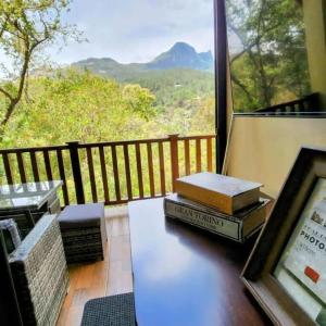 una mesa con libros en un balcón con vistas en Cabaña de montaña en Altos del María, en Sorá