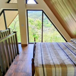 a bedroom with a bed and a large window at Cabaña de montaña en Altos del María in Sorá