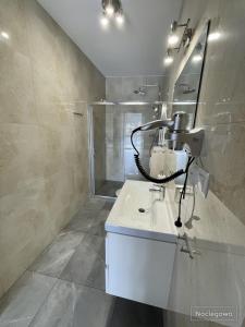 a bathroom with a white sink and a mirror at Ostoja Nad Rzeką in Łeba