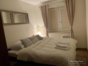 a bedroom with a bed with towels on it at Ostoja Nad Rzeką in Łeba