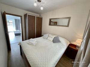 a bedroom with a bed and a mirror on the wall at Ostoja Nad Rzeką in Łeba