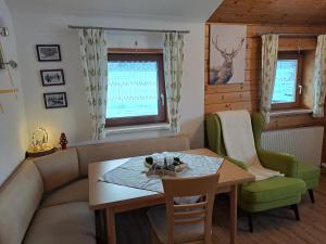 a living room with a table and a couch at Kathis Appartement in Flachau