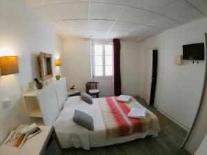 Schlafzimmer mit einem Bett, einem Schreibtisch und einem Fenster in der Unterkunft Le Petit Hôtel in Biarritz