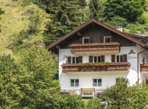 a building with a balcony with flowers on it at Apartments Chalet Zirm in Santa Cristina in Val Gardena