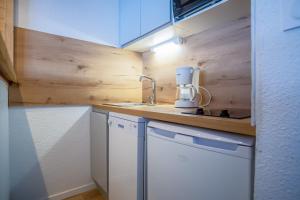 a small kitchen with a white appliance on a counter at Appartement cosy 1 chambre 4 pers face pistes 09 in LʼHuez