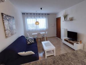 a living room with a blue couch and a table at Esparto y sal in El Pozo de los Frailes