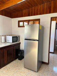 a kitchen with a stainless steel refrigerator and a microwave at Amplia Casa en Paquera in Paquera