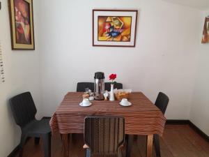 a dining room table with chairs and a coffee maker at El Jardín de Jeni in Cusco