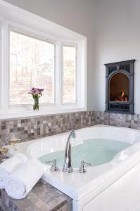 a white bathroom with a tub with a fireplace at Hermann Hill in Hermann