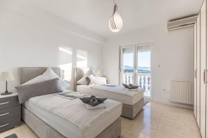um quarto branco com 2 camas e uma janela em Kiki, No 3 em Zadar