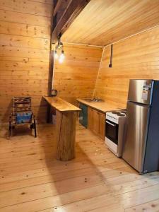 uma cozinha com um frigorífico e uma mesa num camarote em A-frame mestia em Mestia