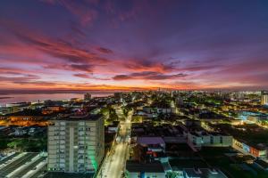 une vue sur la ville la nuit avec un coucher de soleil dans l'établissement Hotel Laghetto Rio Grande, à Rio Grande