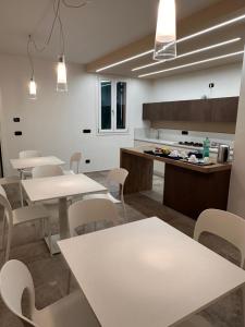 eine Cafeteria mit weißen Tischen und weißen Stühlen in der Unterkunft IL FENICOTTERO in Comacchio