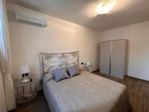 ein Schlafzimmer mit einem Bett mit zwei blauen Kissen in der Unterkunft IL FENICOTTERO in Comacchio
