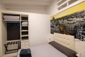 ein Schlafzimmer mit einem Bett und einem Wandgemälde in der Unterkunft Loft madrid in León