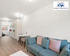 a living room with a blue couch and a table at Bright and Stylish One Bedroom Flat by Direct2hosts Short Lets with great location! in London